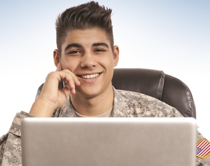 A young male soldier at a laptop.