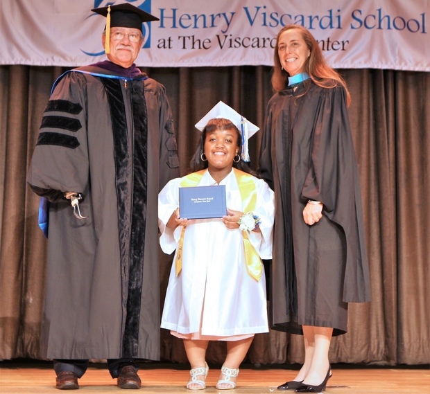Alexa receiving her high school diploma on stage with President & CEO, John D. Kemp, and Henry Viscardi School Board Chair, Bath A. Daly. 