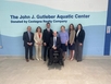 Members of the Castagna and Gutleber families pose alongside Viscardi CEO Dr. Chris Rosa and board member Russ Cusick. The wall behind them reads: The John J. Gutleber Aquatic Center, donated by Castagna Realty.